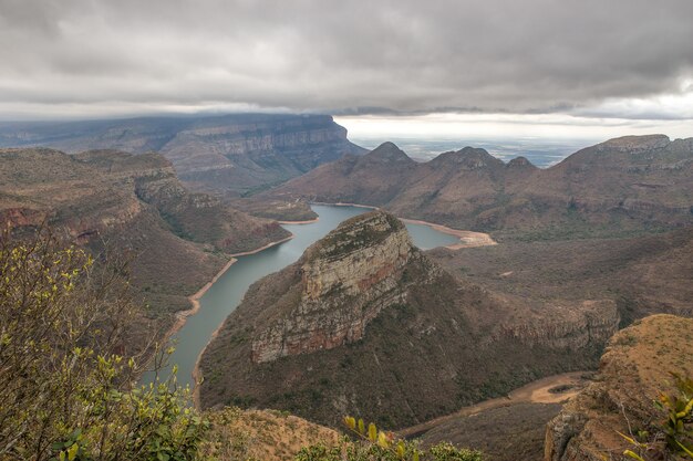 Disparo de gran angular de un pequeño lago rodeado de montañas y vegetación durante el día