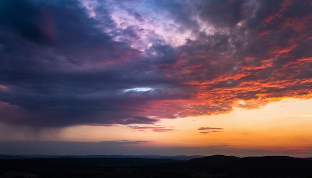 Disparo de gran angular de varias nubes en el cielo durante el atardecer pintado en varios colores