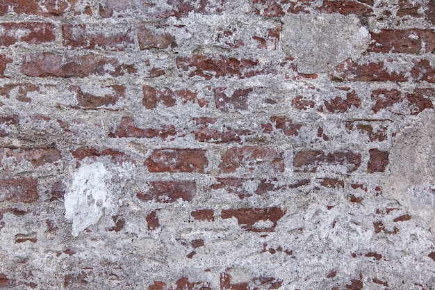 Disparo horizontal de un antiguo muro de piedra roja y blanca con textura y algo de yeso