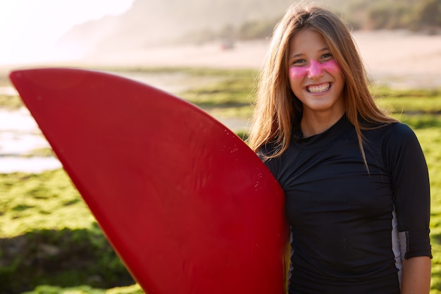 Disparo horizontal de bastante sonriente joven mujer caucásica con pelo largo y recto