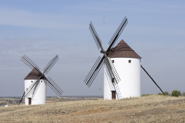 Disparo horizontal de dos molinos blancos en un campo vacío en Belmonte, España