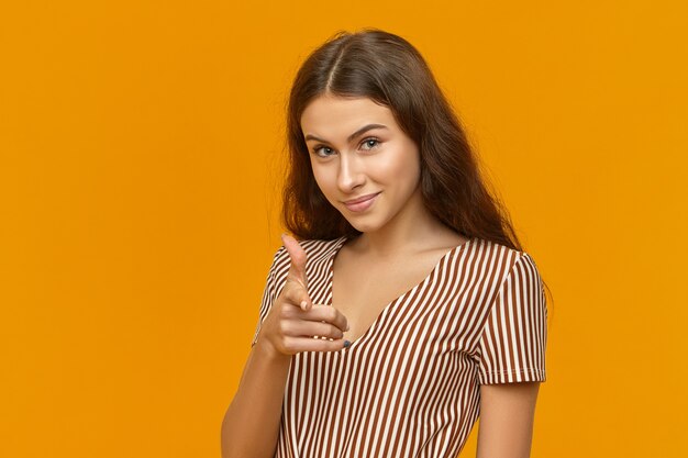 Disparo horizontal de hermosa joven de pelo oscuro de ojos azules europeo dedo índice apuntando