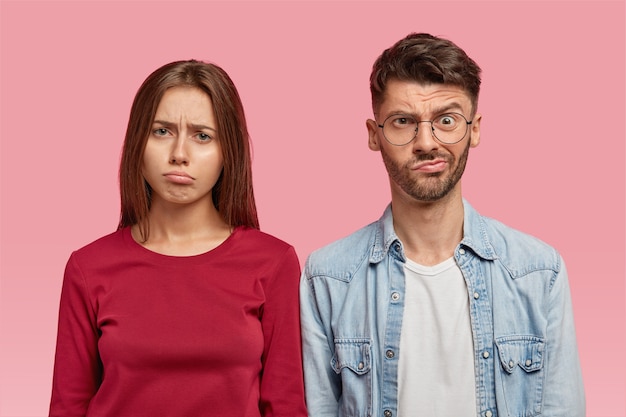 Foto gratuita disparo horizontal de mujer y hombre sombríos con expresiones de desconcierto