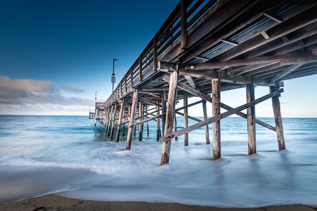 Disparo de larga exposición de un muelle en la playa en California