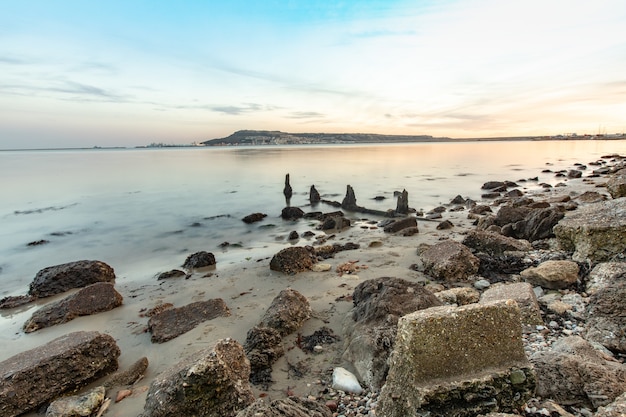 Disparo de larga exposición de las piedras en la orilla cerca de Portland, Weymouth, Dorset, Reino Unido