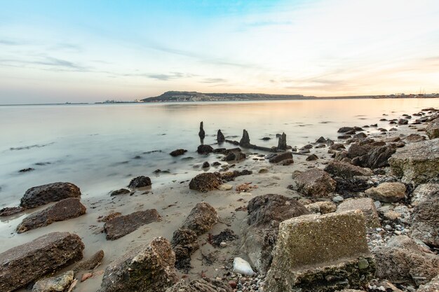 Disparo de larga exposición de las piedras en la orilla cerca de Portland, Weymouth, Dorset, Reino Unido