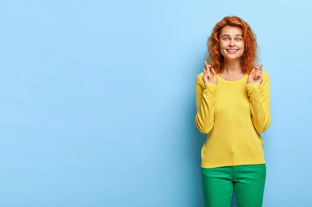 Foto gratuita disparo de media longitud de alegre esperanza femenina de jengibre pide deseo y anticipa algo