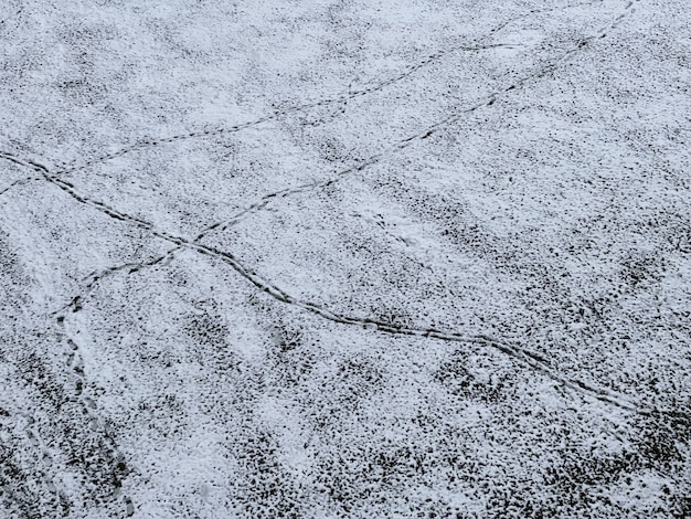 Disparo de piso de concreto cubierto de nieve con rastros sobre ella