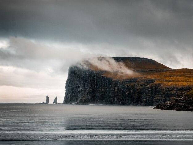 Disparo que captura la hermosa naturaleza de las Islas Feroe, mar, montañas, acantilados