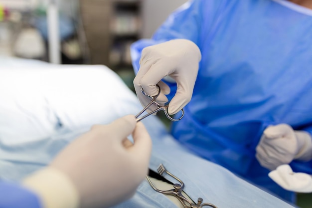 Foto gratuita disparo en el quirófano el asistente entrega instrumentos a los cirujanos durante la operación los cirujanos realizan la operación médicos profesionales que realizan la cirugía