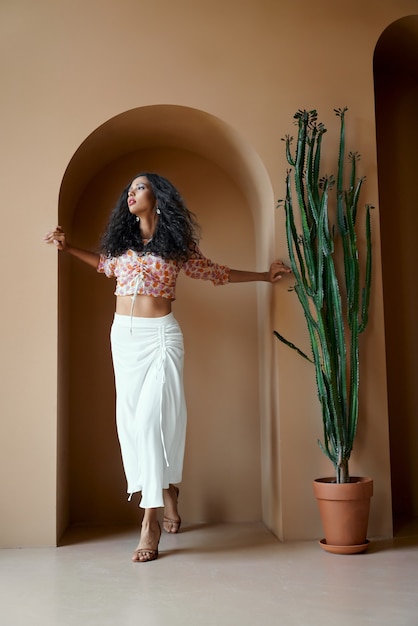 Foto gratuita disparo de retrato de chica elegante con pelo rizado junto a la pared