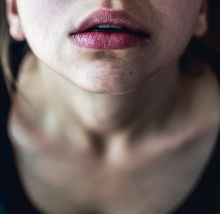 Foto gratuito disparo selectivo de cerca de arriba de una mujer con piel pálida y labios rosados secos mirando hacia arriba