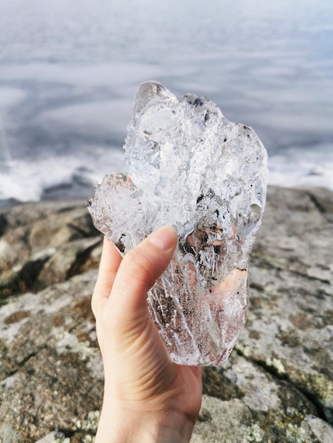 Foto gratuita disparo vertical de alguien sosteniendo un gran trozo de hielo en el lago farris en noruega