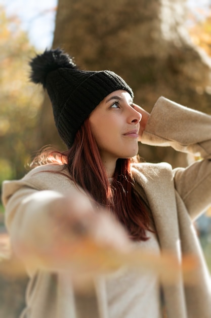 Foto gratuita disparo vertical de una bonita mujer caucásica vistiendo una gorra de invierno al aire libre