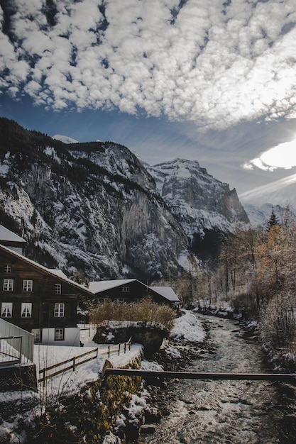 Disparo vertical de cabañas y edificios en una zona turística rodeada de colinas rocosas y nieve