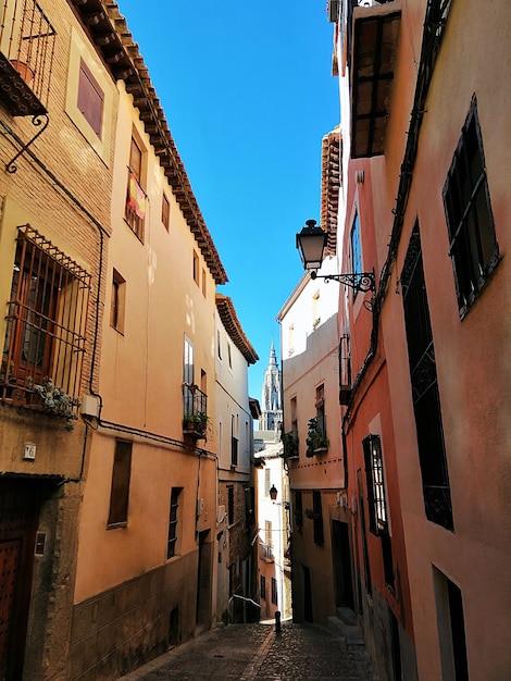 Disparo vertical de una calle estrecha con coloridos edificios cortos en toledo, españa