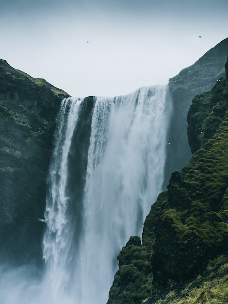 Disparo vertical de la cascada Skogafoss en Islandia en un día sombrío