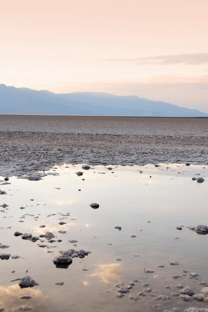 Disparo vertical de un charco lleno de rocas con el reflejo de la puesta de sol