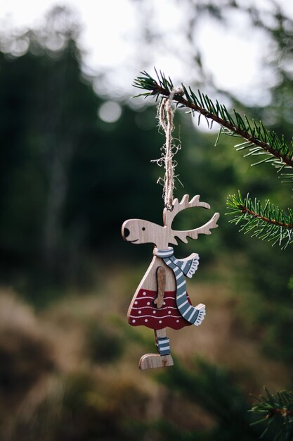 Disparo vertical de ciervos de juguete colgados en el árbol de Navidad