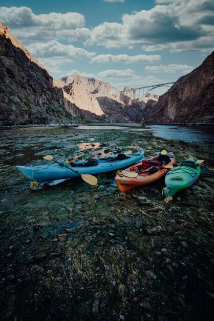 Disparo vertical de coloridos botes de kayak en la orilla del lago en las montañas