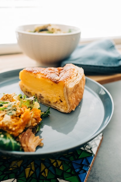 Disparo vertical de una deliciosa tarta de queso y algunas guarniciones en un plato sobre una mesa