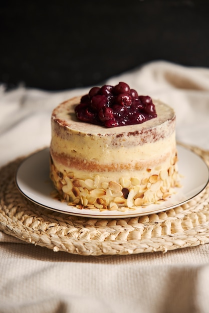 Foto gratuita disparo vertical de un delicioso pastel de cereza con crema en una placa blanca.