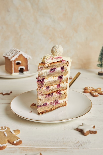 Disparo vertical de un delicioso pastel de Navidad con adornos de pan de jengibre y bola de coco y almendra
