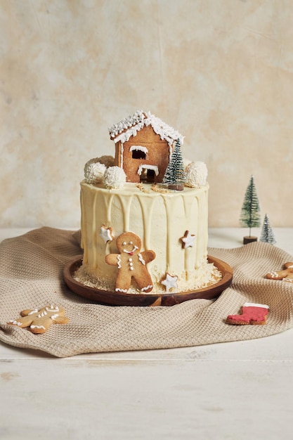 Disparo vertical de un delicioso pastel de Navidad con adornos de pan de jengibre y bolas de almendras de coco