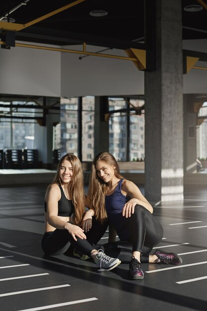 Disparo vertical dos hermanas hermosas hermanas en ropa deportiva leggi