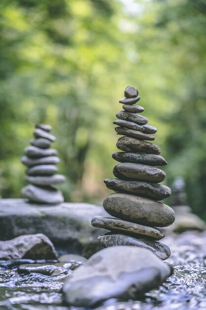 Disparo vertical de dos pirámides de piedra en equilibrio sobre el agua de un río