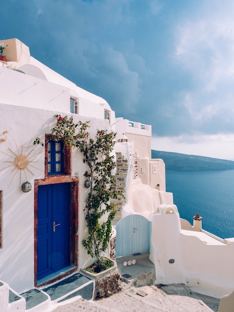 Disparo vertical de un edificio con una puerta azul en Santorini, Grecia