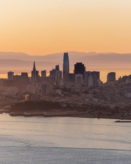 Disparo vertical de los edificios de la ciudad en la distancia cerca del mar