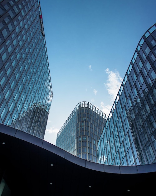 Disparo vertical de edificios de oficinas modernos con grandes ventanas reflectantes bajo la luz del sol