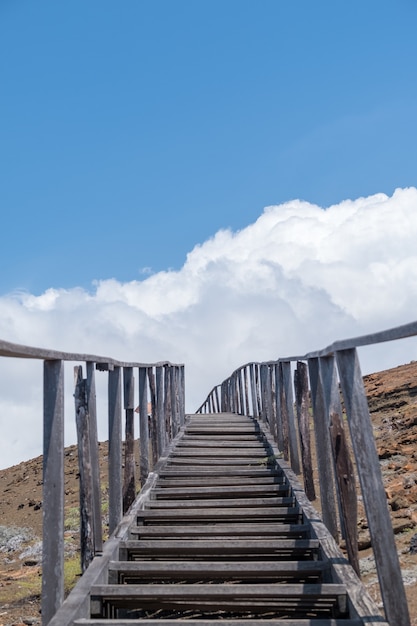 Disparo vertical de una escalera que conduce a las montañas tocando el cielo en las Islas Galápagos, Ecuador