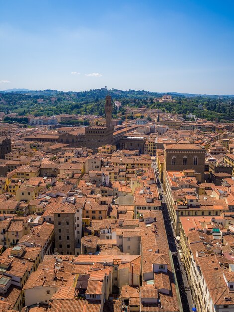 Disparo vertical de Florencia rodeada de edificios y vegetación bajo la luz del sol en Italia