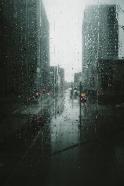 Disparo vertical de gotas de lluvia cayendo por una ventana de vidrio