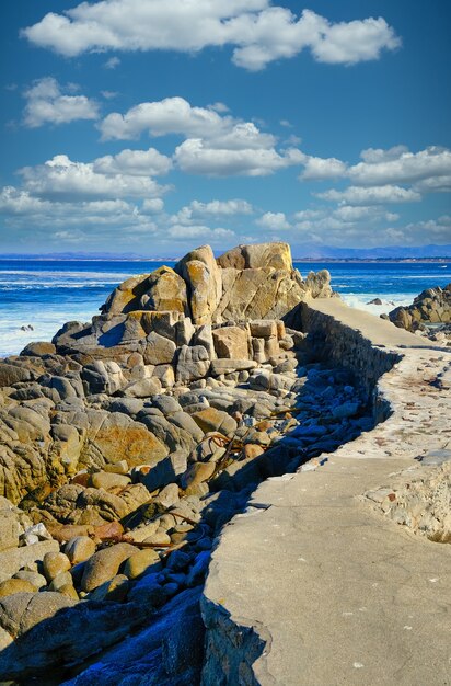 Disparo vertical de una gran cantidad de formaciones rocosas en la playa bajo el hermoso cielo nublado