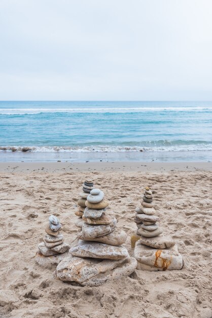 Disparo vertical de guijarros apilados unos sobre otros en un equilibrio en la playa.