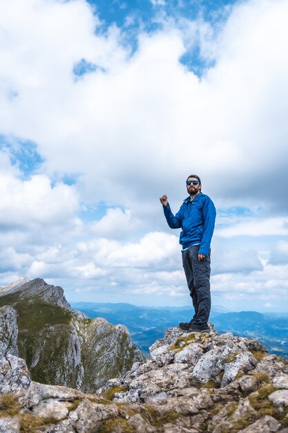 Disparo vertical de un hombre de pie en la cima de la montaña Aitzkorri en Gipuzkoa