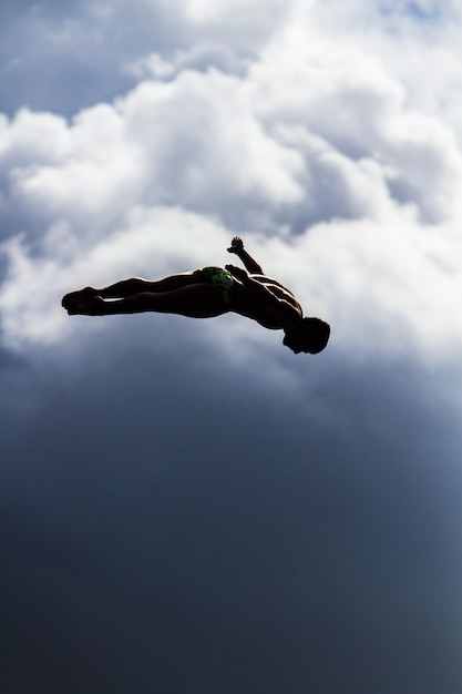 Disparo vertical de un hombre saltando en el aire con un cielo borroso