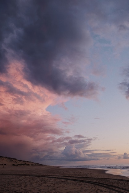 Disparo vertical de un impresionante cielo púrpura en la playa después del atardecer