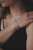 Foto gratuita disparo vertical de una joven mujer vistiendo una hermosa pulsera de plata