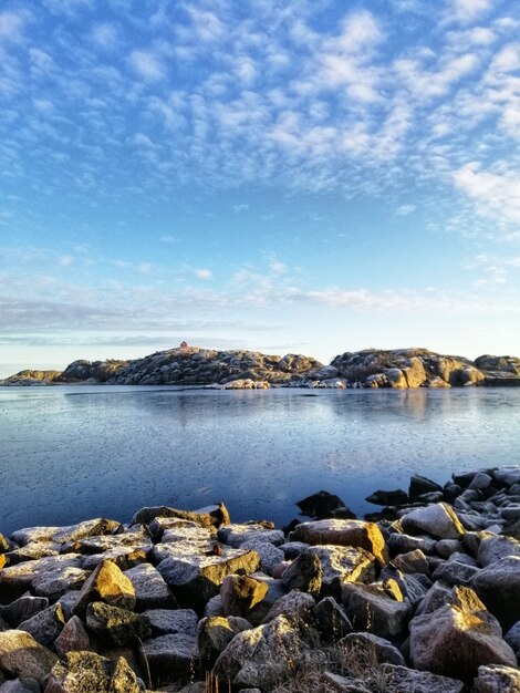 Disparo vertical de un lago rodeado por formaciones rocosas en Stavern Noruega