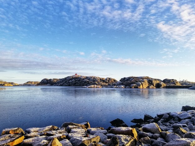 Disparo vertical de un lago rodeado por formaciones rocosas en Stavern Noruega