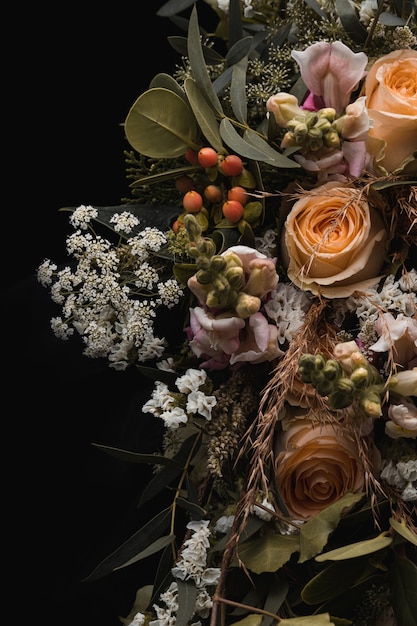 Foto gratuita disparo vertical de un lujoso ramo de rosas naranjas y flores blancas sobre un negro