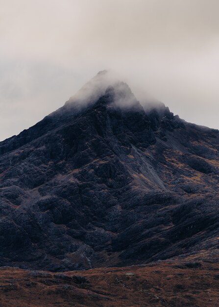 Disparo vertical de una montaña cubierta por una nube de niebla en Escocia, Isla de Skye