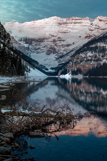 Disparo vertical de las montañas nevadas reflejadas en el lago Louise en Canadá