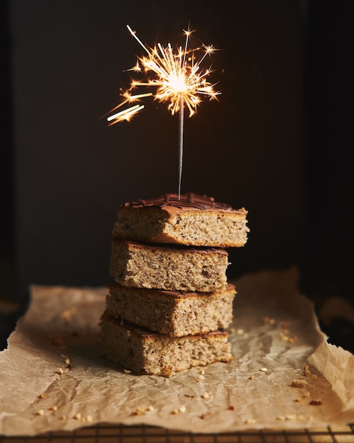 Disparo vertical de un montón de deliciosos pasteles de nueces con glaseado de chocolate y brillo en la parte superior