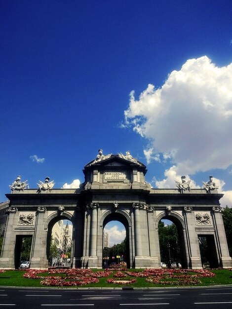 Disparo vertical del monumento neoclásico Puerta de Alcalá en Madrid bajo un cielo azul
