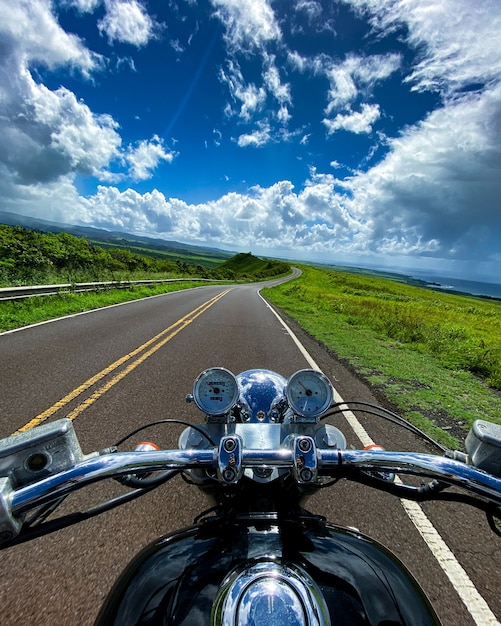 Disparo vertical de una moto en la carretera con la hermosa vista de las montañas en Kauai, Hawaii